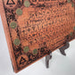 Close up of medieval alchemical symbols engraved on mahogany wood board
