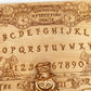 Side view of engraved wooden Wonderland Ouija board showing  wood grain
