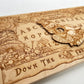 Flat wooden Ouija board with Alice Wonderland imagery displayed on tabletop

