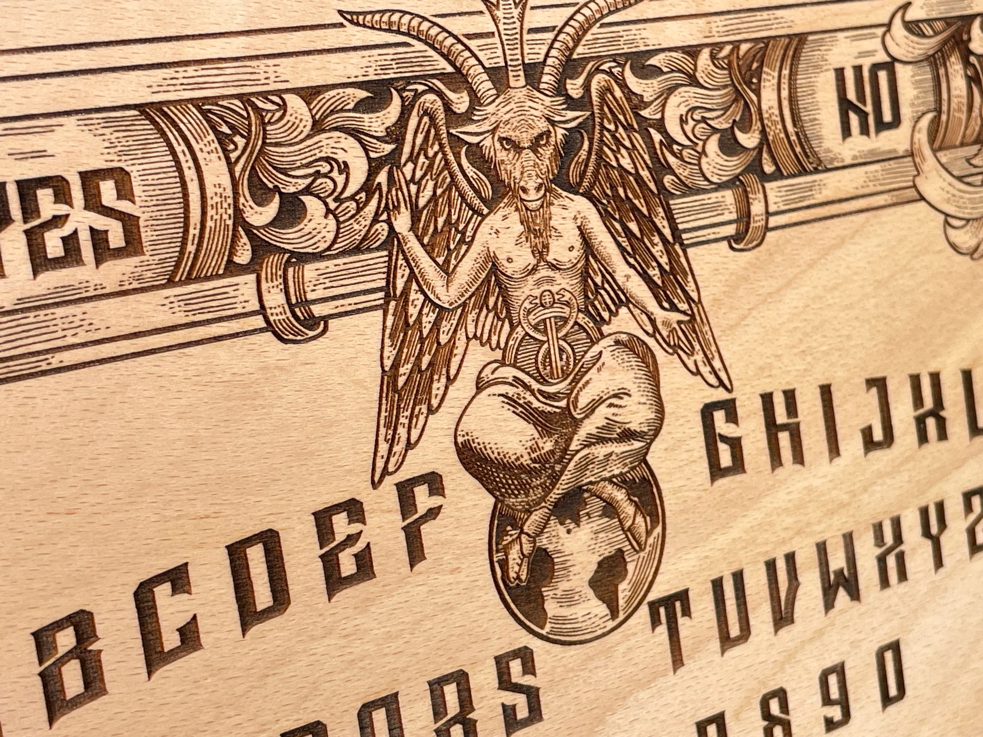 Close up detail of Baphomet engraving on wooden Ouija spirit board showing fine line carving, esoteric symbols, and dark gothic artwork on natural wood grain
