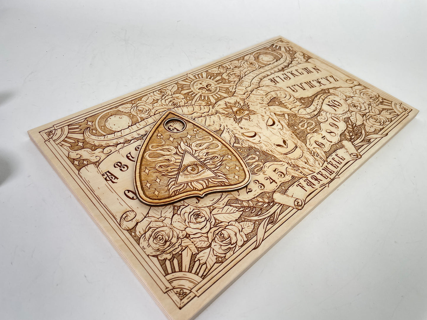Wooden Ouija board with planchette celestial motifs and letters for intuitive spirit communication

