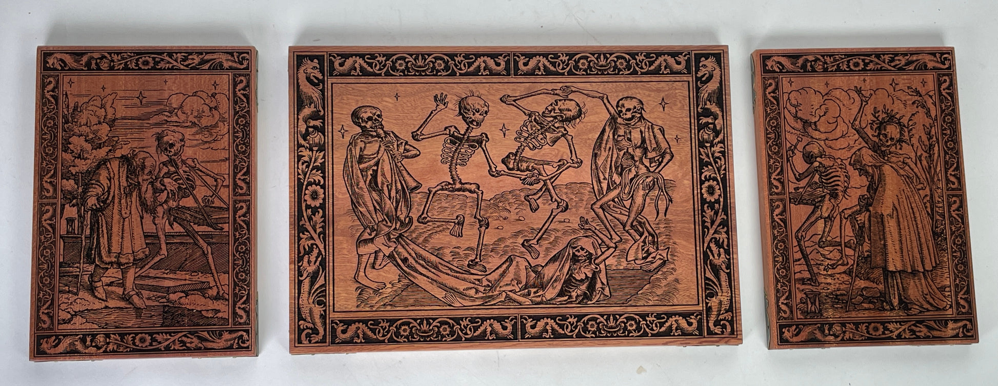 Danse Macabre mahogany wall art triptych engraved with medieval Dance of Death scenes
