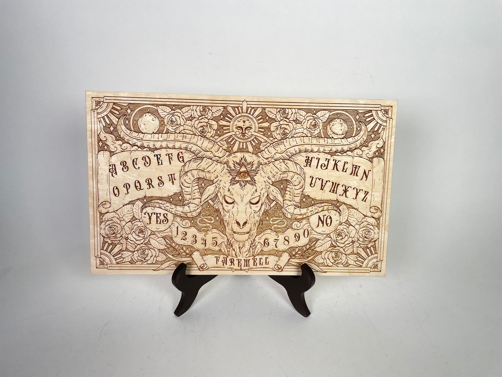 Wooden Ouija board with celestial motifs and letters for intuitive spirit communication
