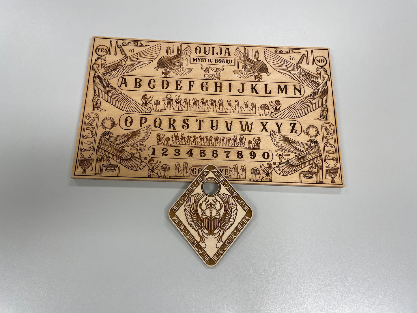 Solid wood Ouija board with Egyptian hieroglyphic design and mythological motifs and wooden planchette
