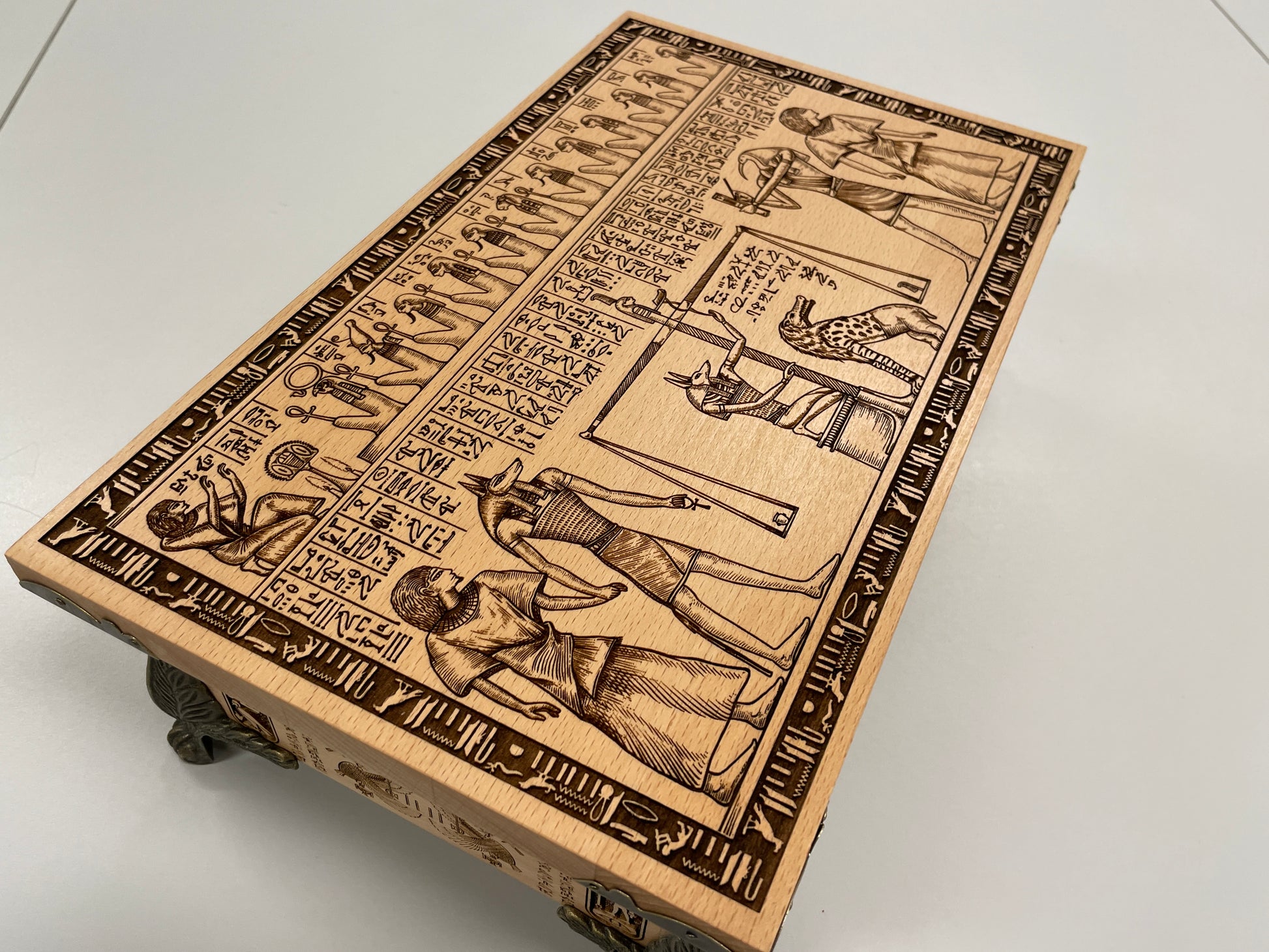 Close up of Weighing of the Heart engraving from Egyptian Book of the Dead on wooden tarot deck holder
