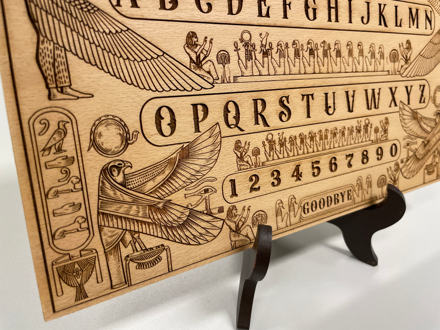 Close up engraving of Egyptian mythology spirit board with planchette on wood

