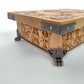 Wooden box with intricate carvings and metal accents on a white background
