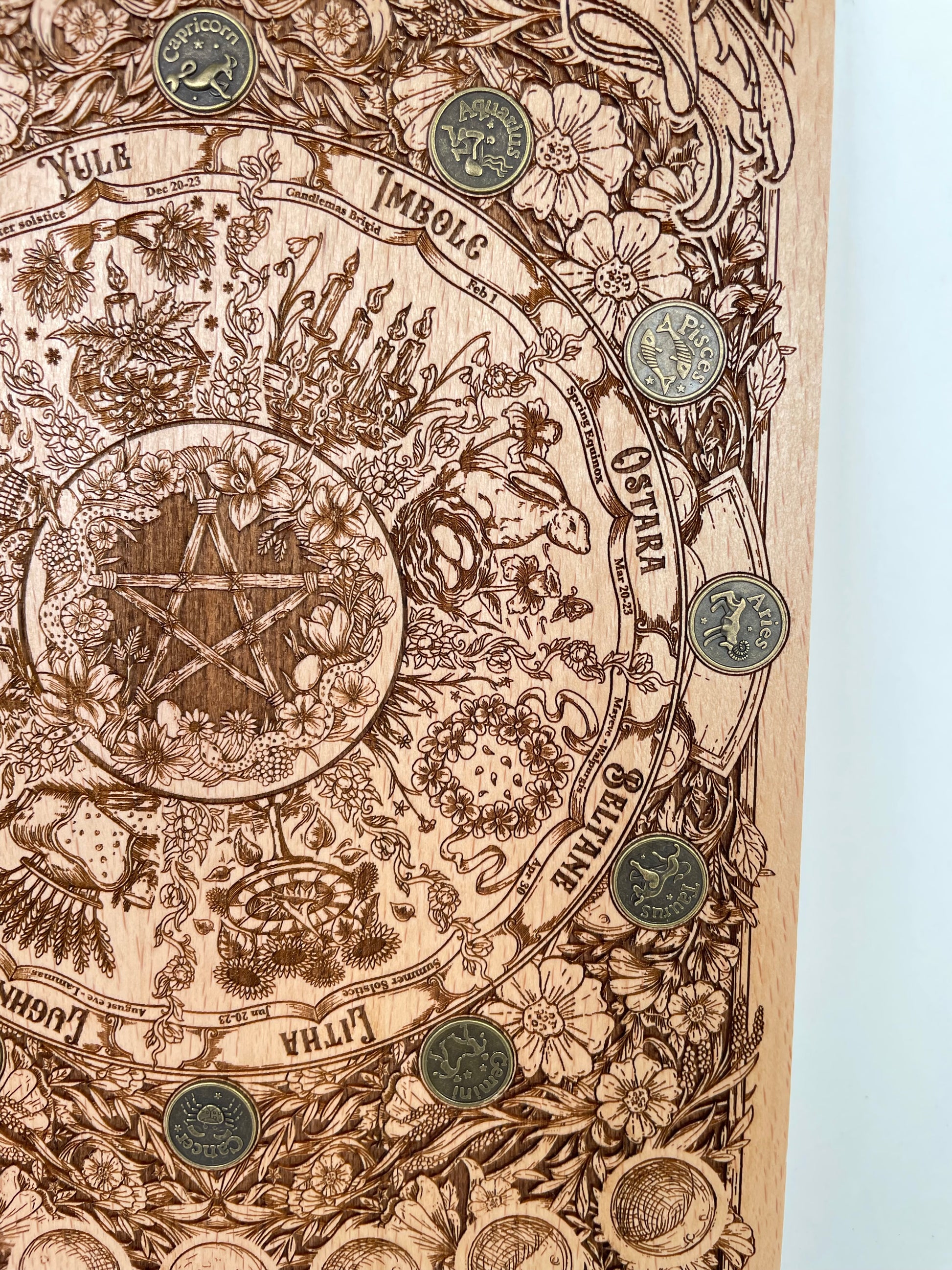 Decorative wall art with intricate designs and symbols on a wooden frame.