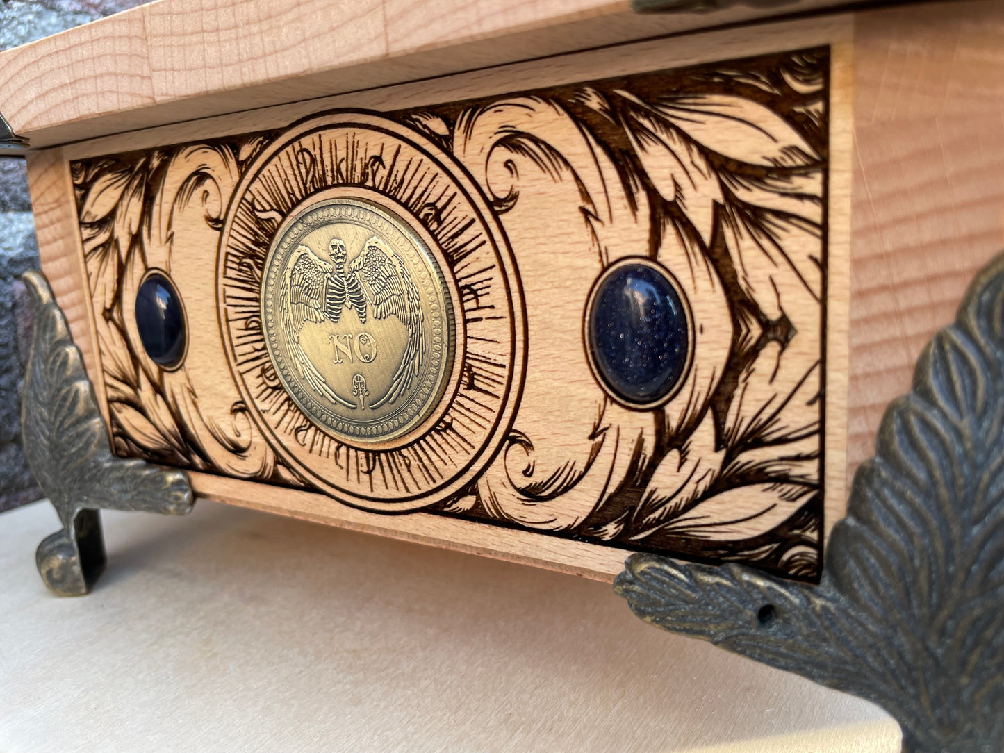 Close up of alchemical symbols and zodiac l engraving on wooden tarot box with ouija coin
