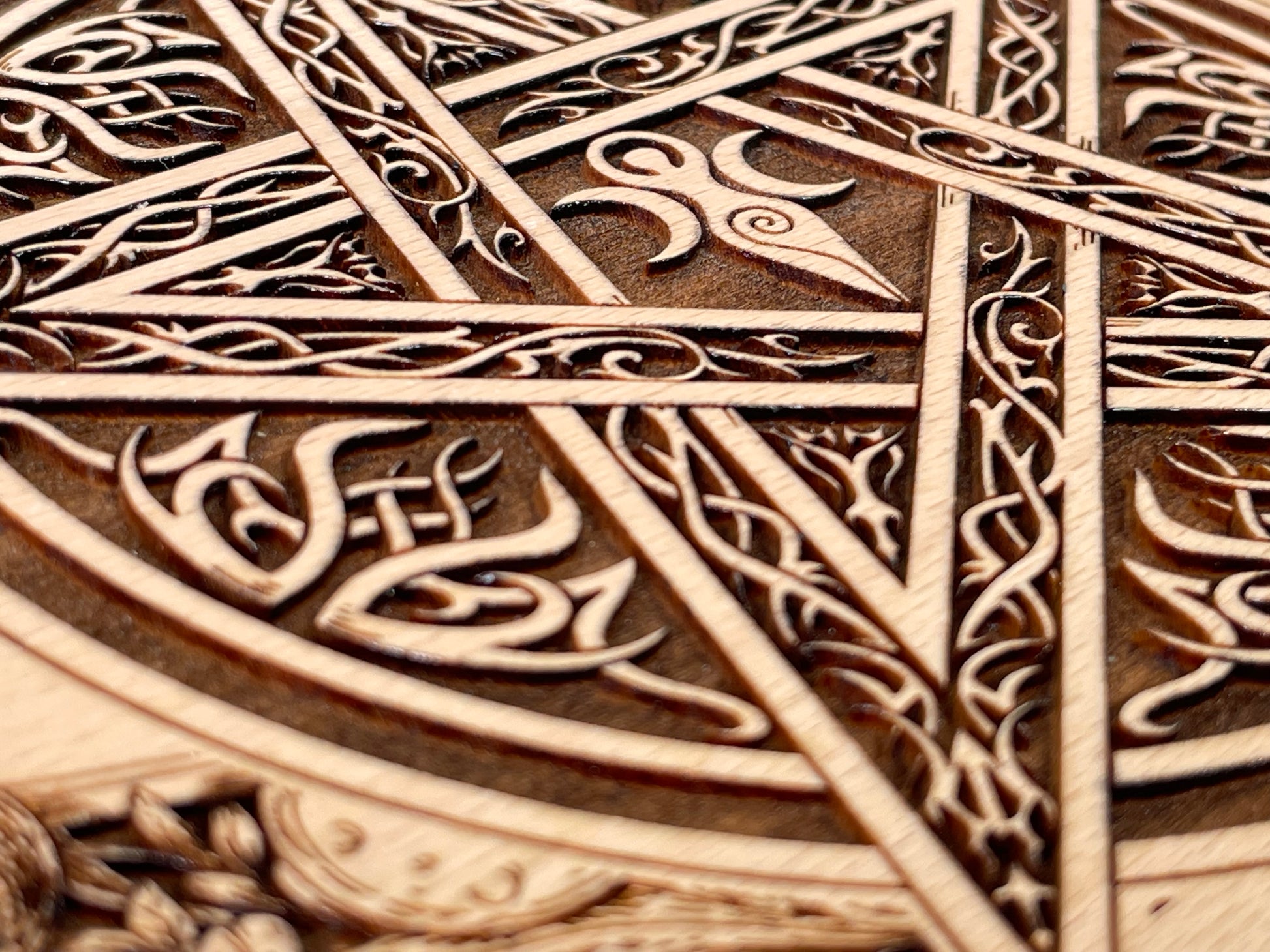 Close up of Celtic pentagram engraving on wooden ritual altar board
