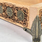 Decorative wooden box with metal accents and engraved symbols on a white surface.