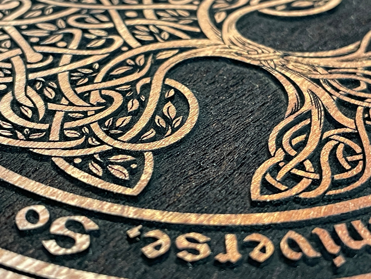 Close up of Tree of Life deep engraving with As Above So Below text on mahogany Wiccan ritual altar table
