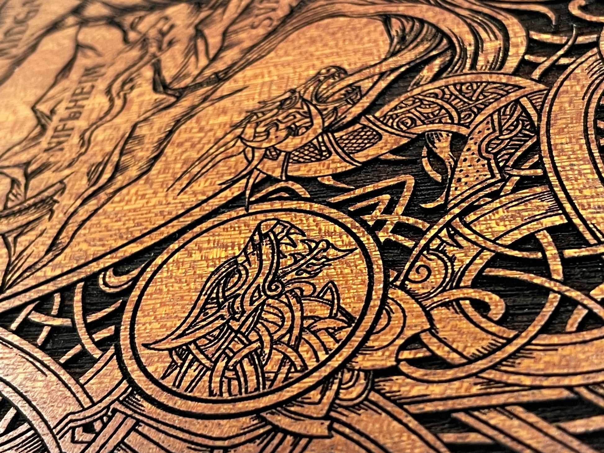 Close up of engraved Yggdrasil Tree of Life on mahogany wood with gold accents
