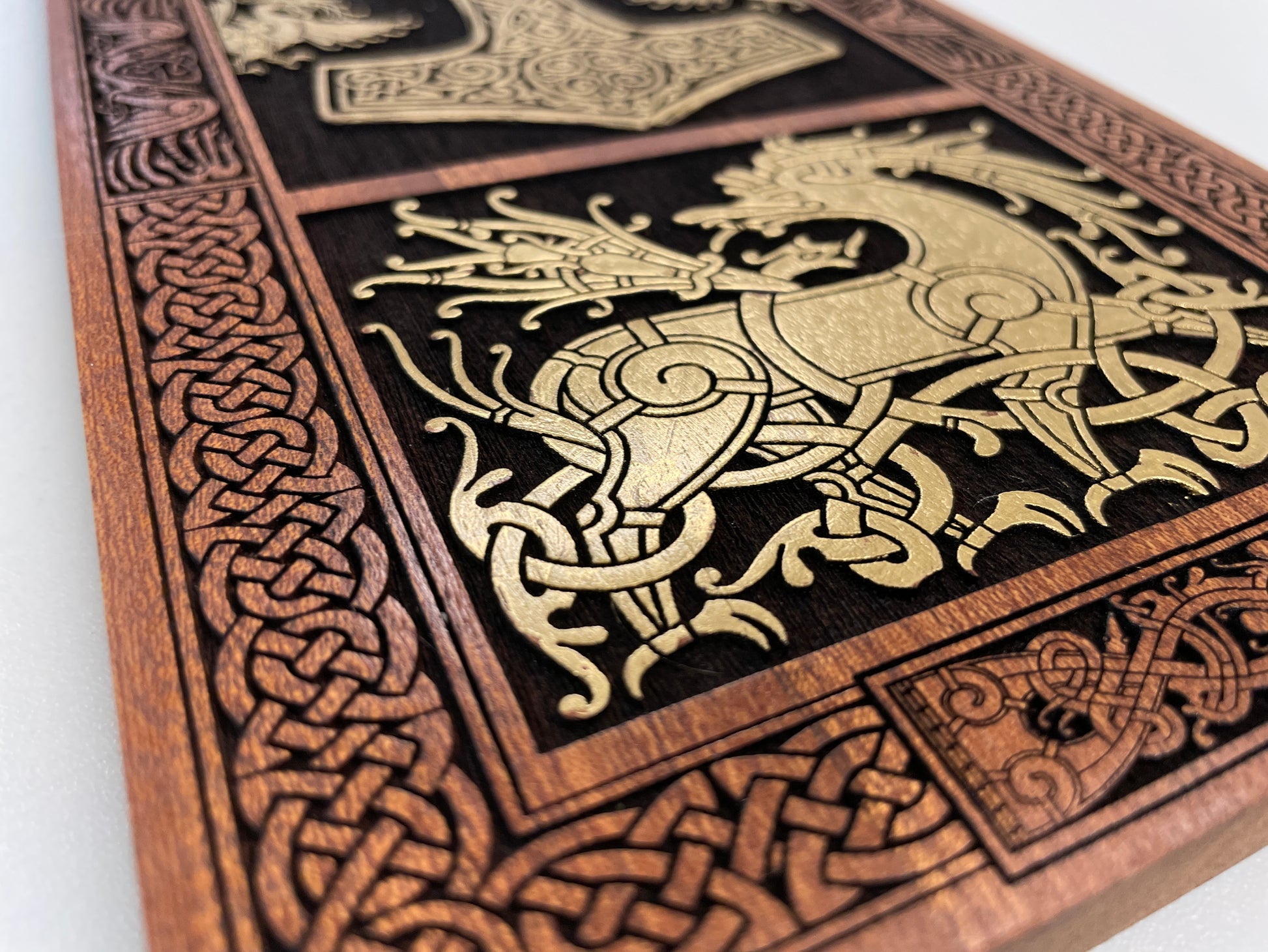 Wooden panel with intricate Viking carvings and a dragon design on a white background