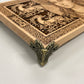 Decorative wooden board with intricate carvings and Freya on a white background