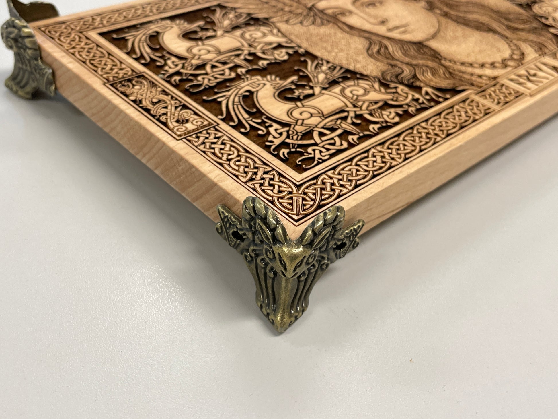 Decorative wooden board with intricate carvings and Freya on a white background
