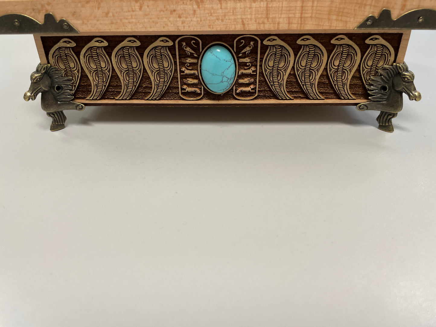 Detailed wood engraving of Eye of Horus altar box, Egyptian symbolism with winged deity and protective serpent border front view