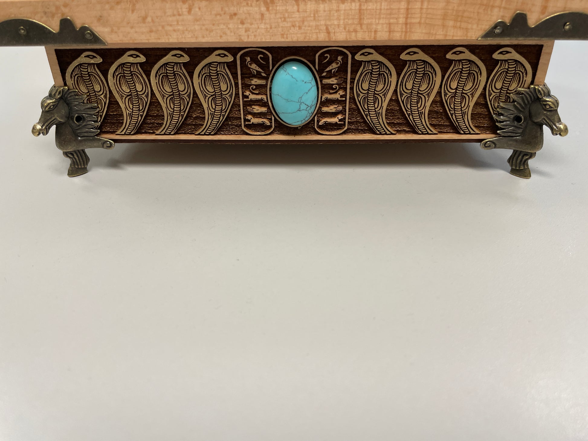 Detailed wood engraving of Eye of Horus altar box, Egyptian symbolism with winged deity and protective serpent border front view