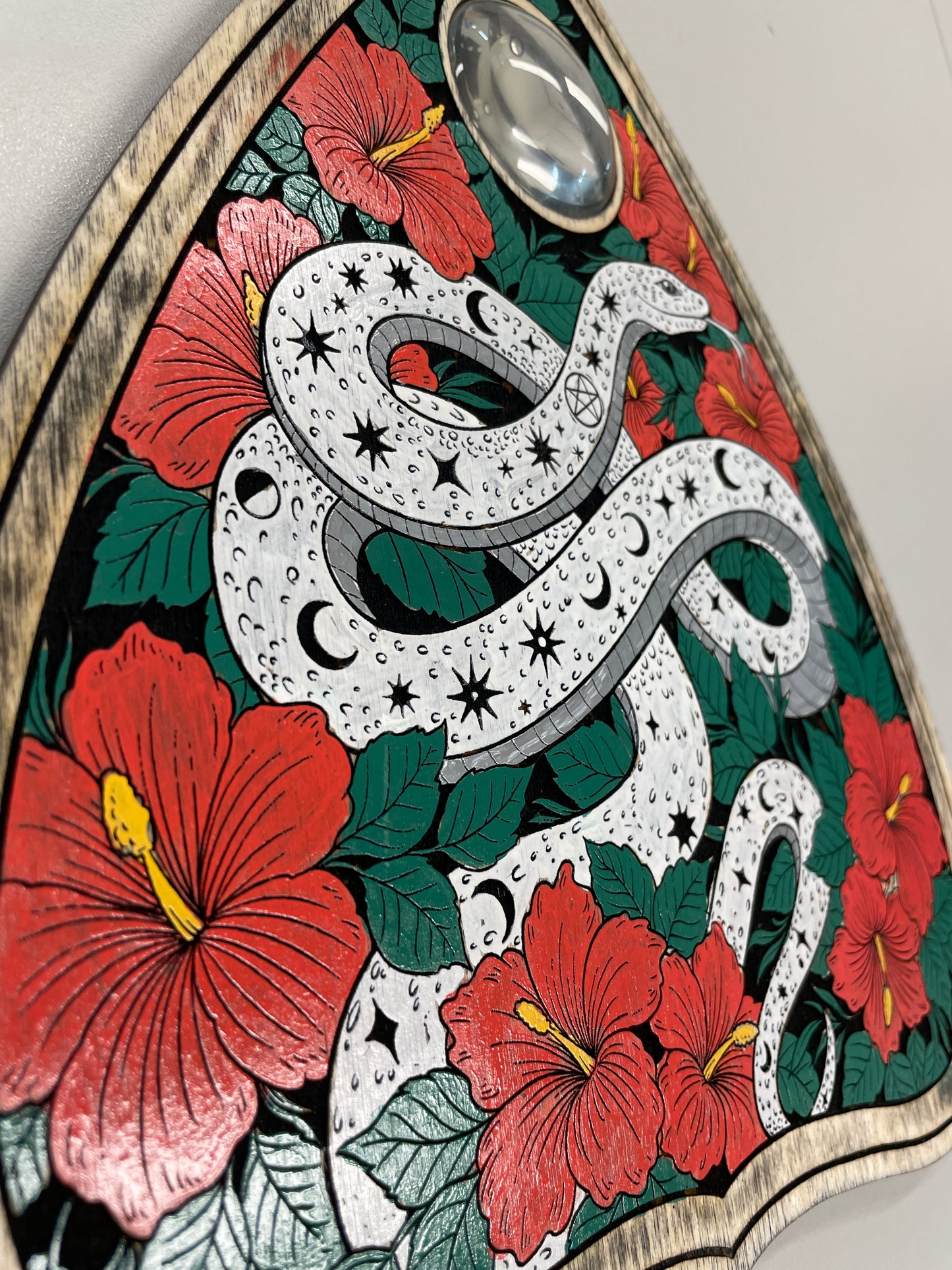 detailed view of Moon and star serpent Ouija board planchette wooden wall hanging