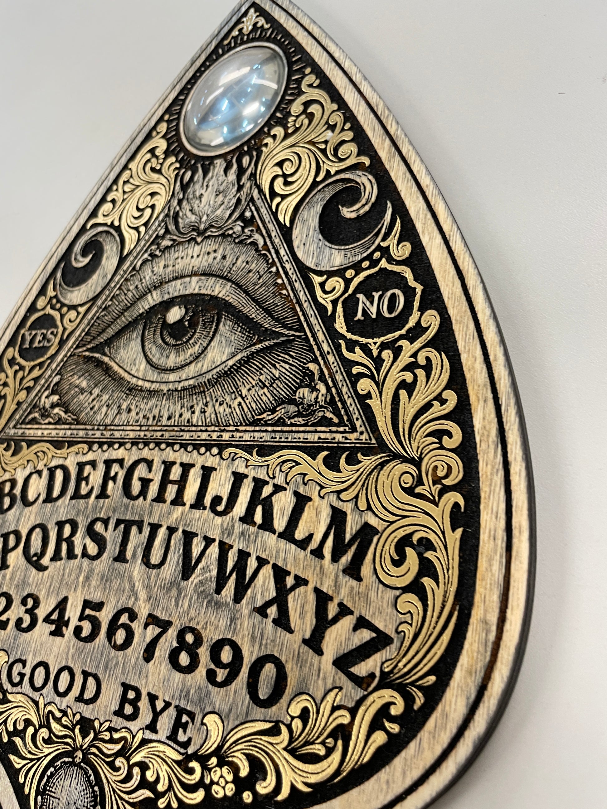 detailed view of  Ouija board wall art wooden spirit board planchette with all seeing eye gothic occult wall decoration