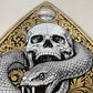 Decorative design with a skull and snake on a gold and black background
