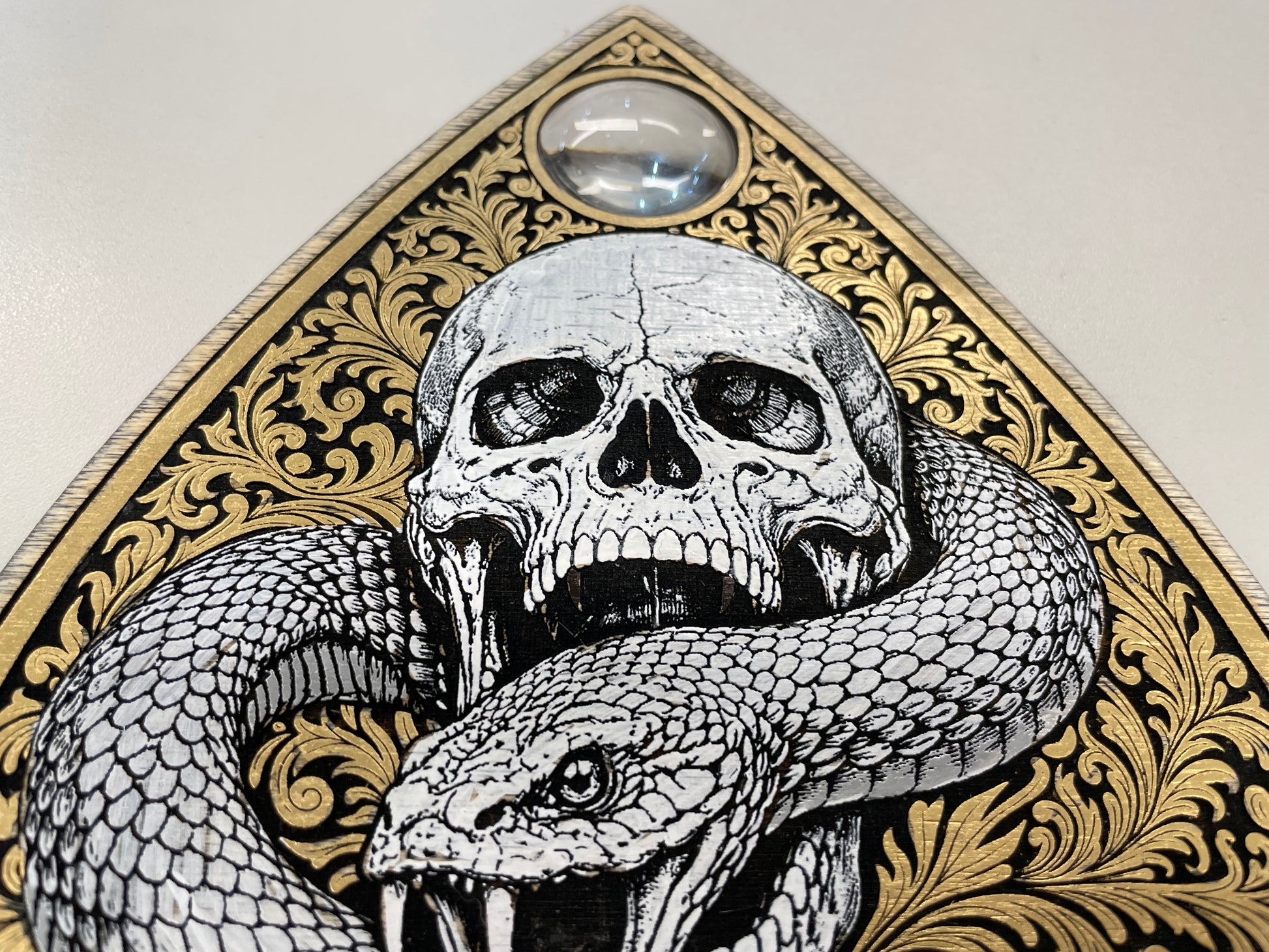 Decorative design with a skull and snake on a gold and black background