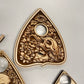 close up engraved ouija planchette skull snake design wooden spirit board tool