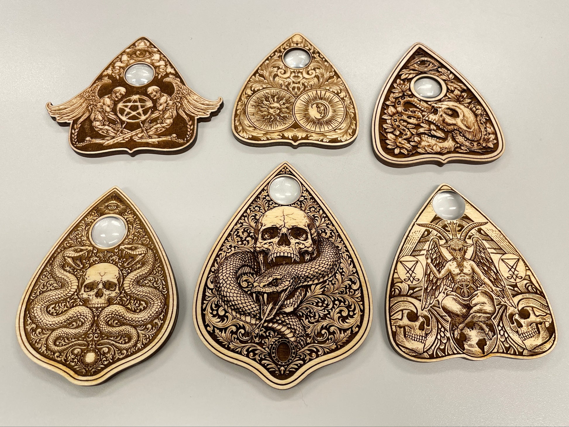 engraved wooden ouija planchettes set with skull serpent and occult symbols collection