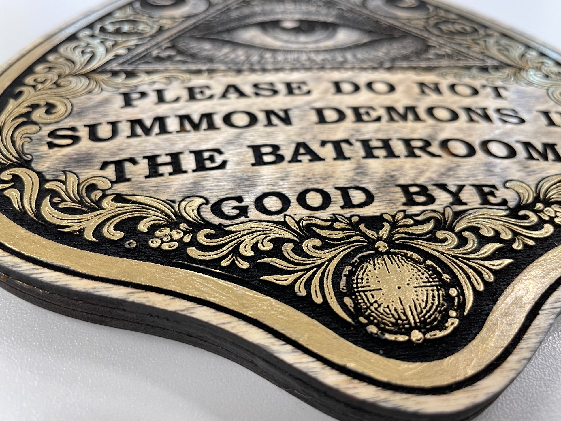 detail view of Spirit board themed planchette wall decor all seeing eye triangle with glass lens