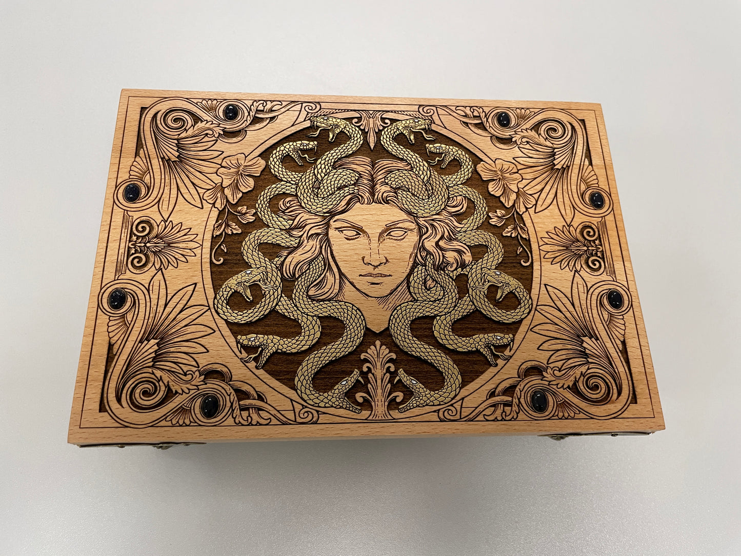 Wooden box with Medusa design on a white background