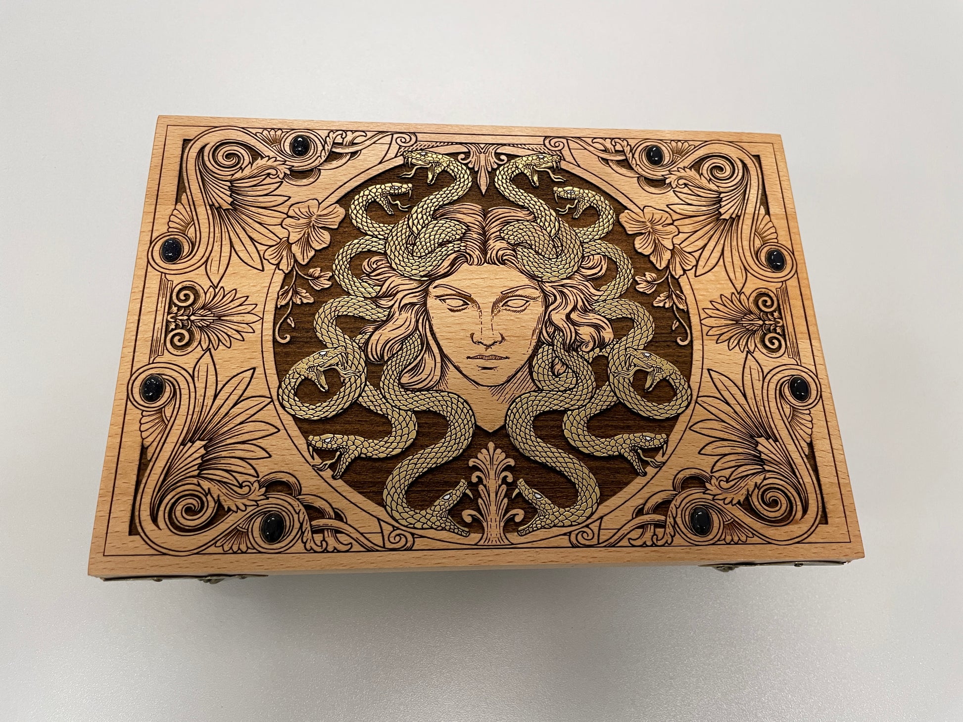 Wooden box with Medusa design on a white background