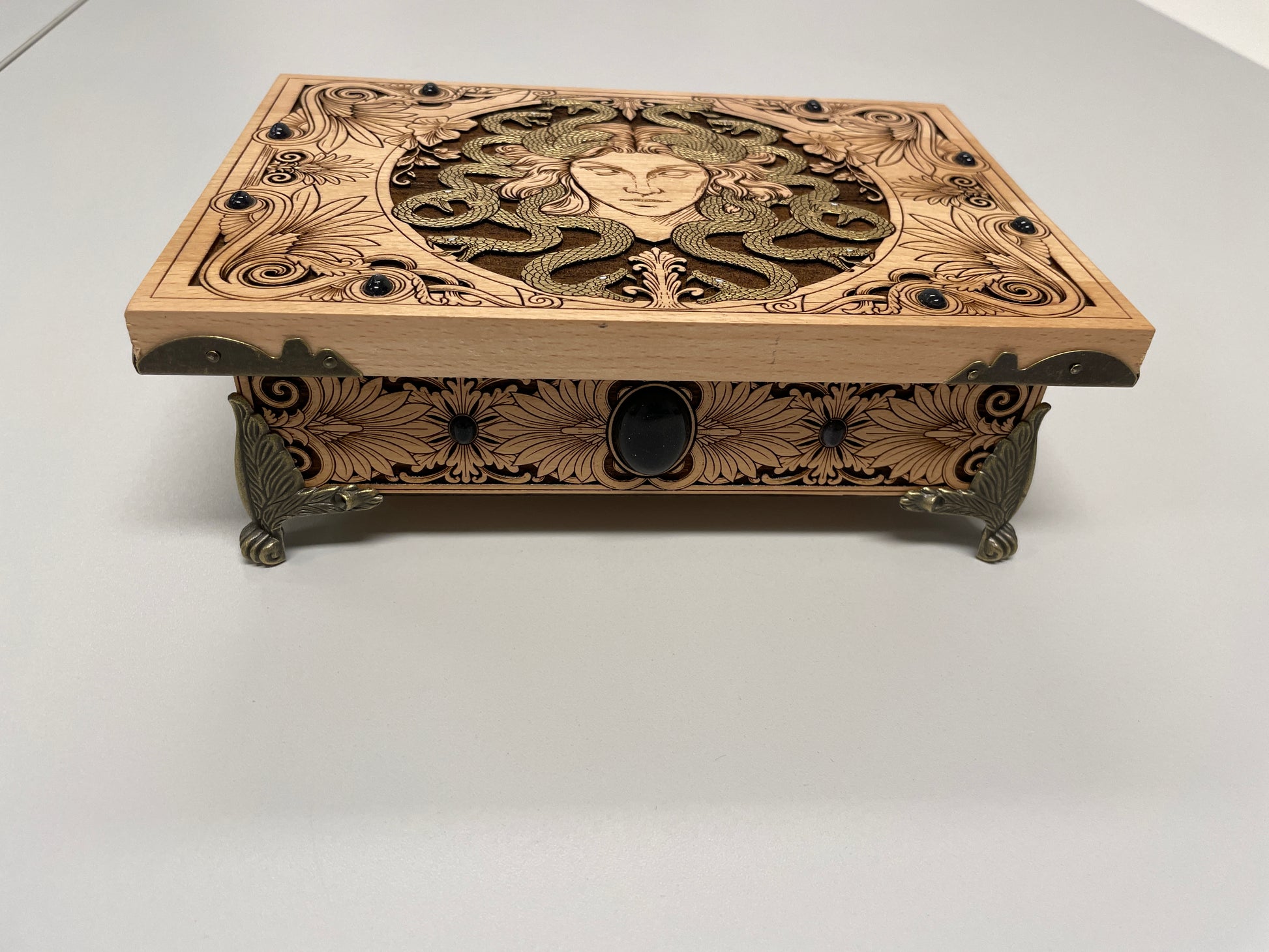 Decorative Medusa wooden box with intricate carvings on a white background