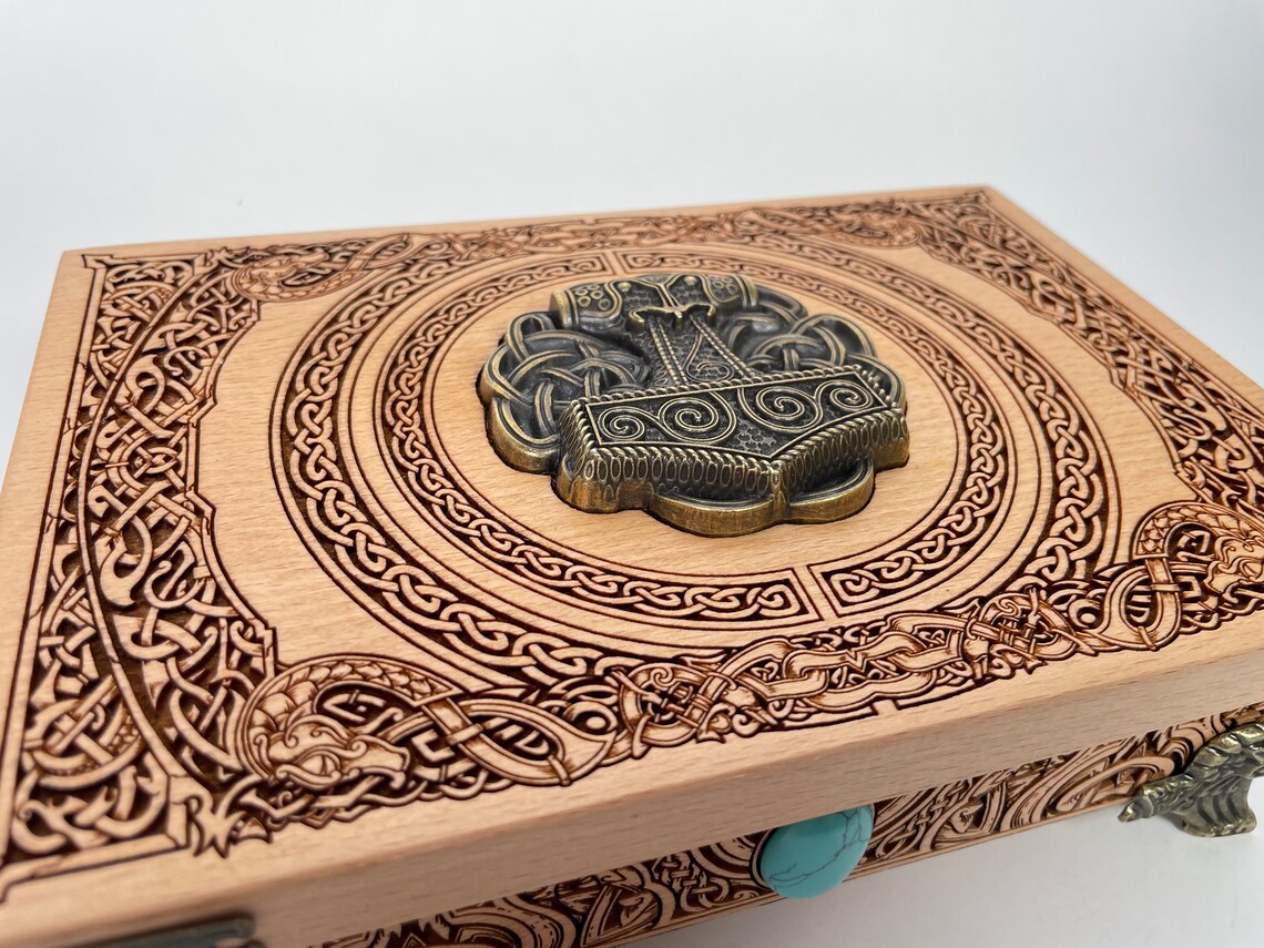 Close up of Mjölnir and Vegvísir engraving on Viking altar wooden box
