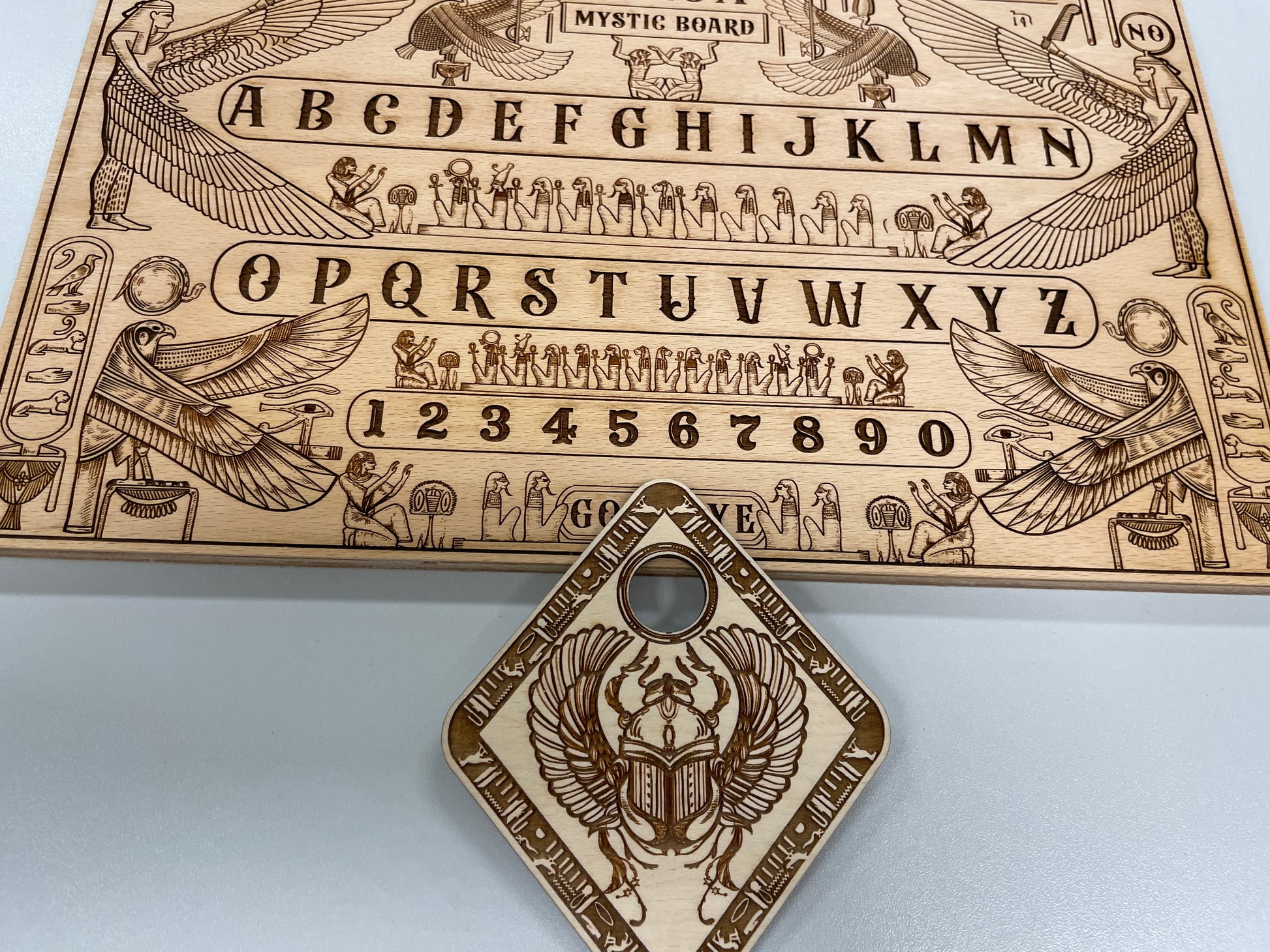 Solid wood Ouija board with Egyptian hieroglyphic design planchette  and mythological motifs
