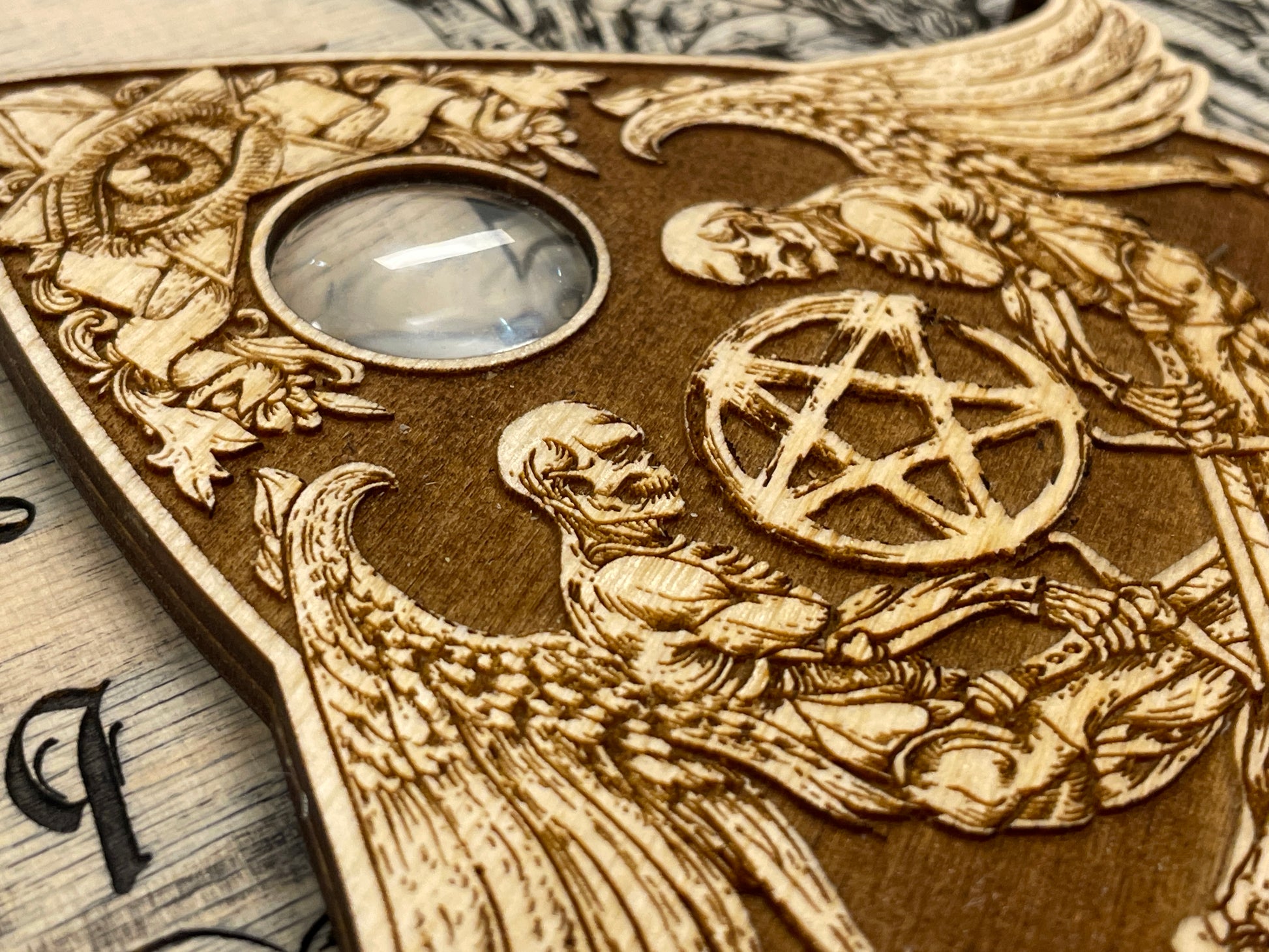Close up detail of engraved gothic planchette with glass eye