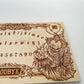 Close up of Pennywise horror clown engraving on wooden Ouija spirit board

