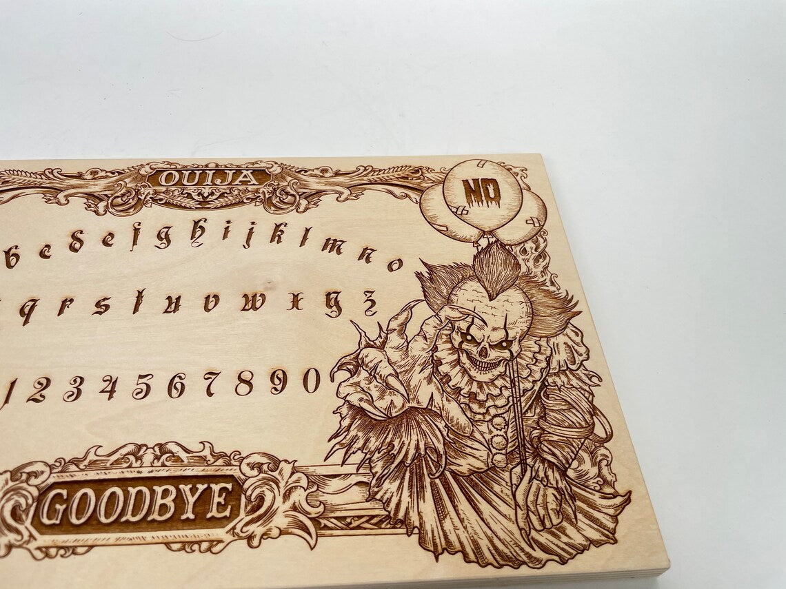 Close up of Pennywise horror clown engraving on wooden Ouija spirit board
