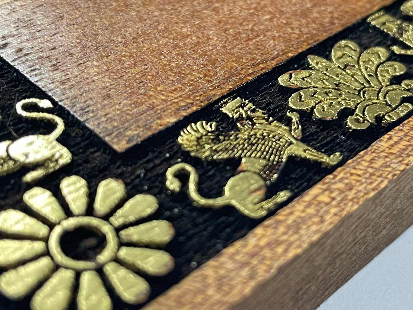 Close up of Faravahar Zoroastrian symbol deeply engraved in real mahogany wood, hand painted Persian spiritual wall art, not a print
