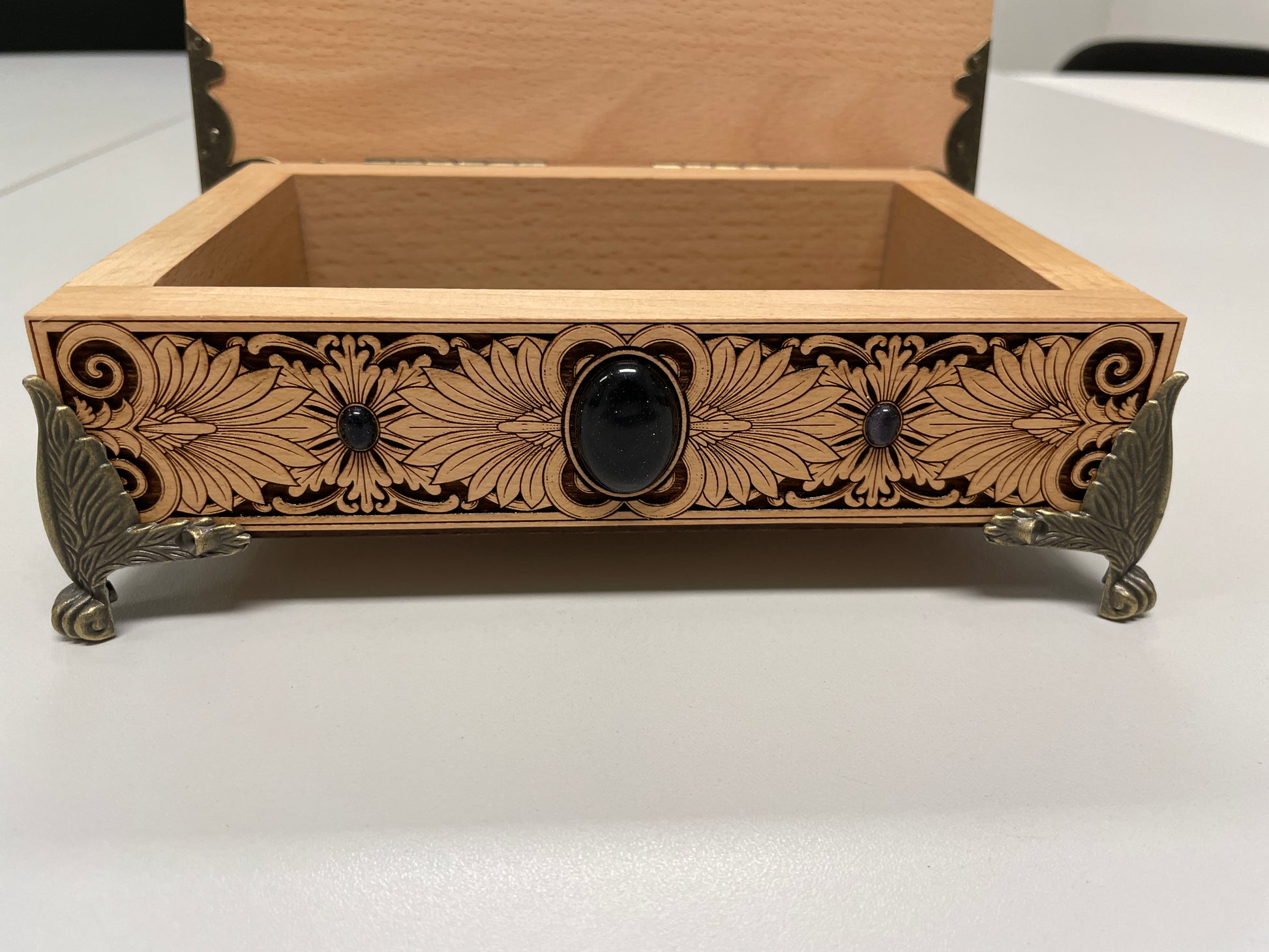 Decorative wooden box with intricate carvings on a white surface