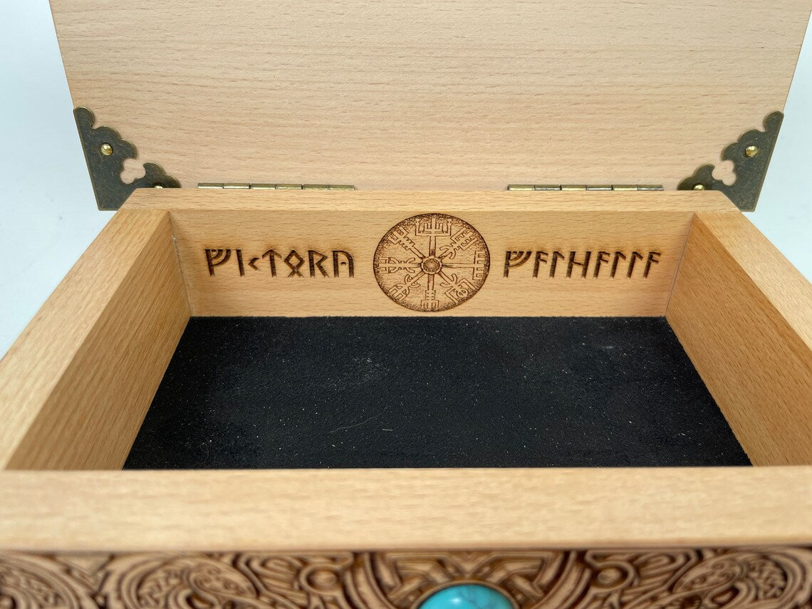 Close up of Mjölnir and Vegvísir engraving on Viking altar wooden box
