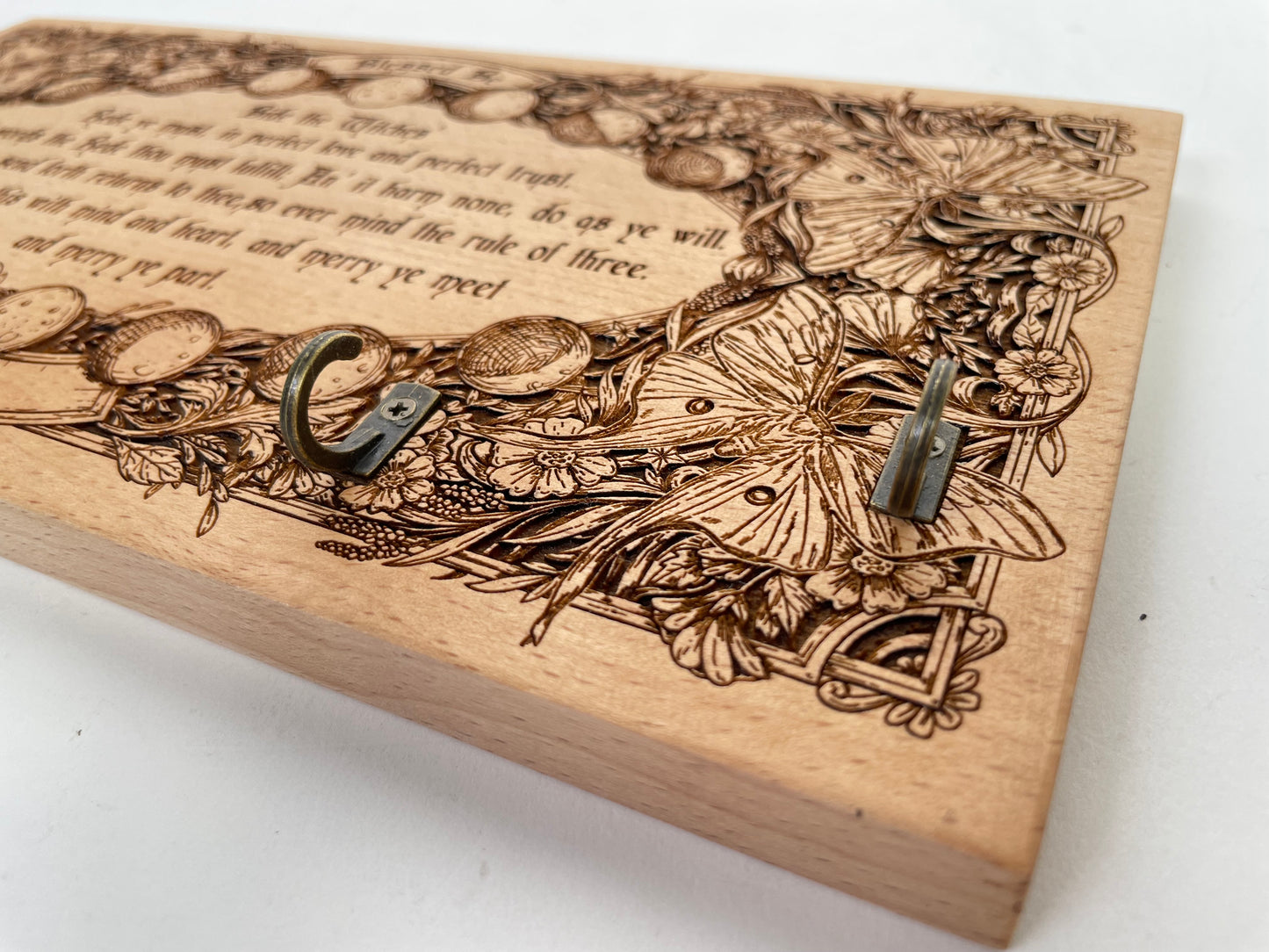 Close-up of moon phases engraving and Wiccan Rede text on wooden pendulum holder
