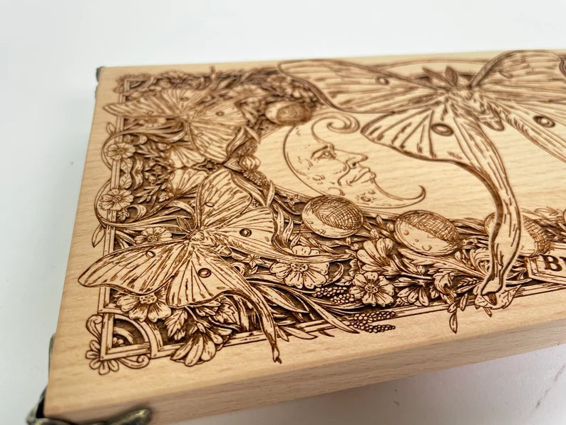 Close up of Blessed Be text moon phases and Luna Moth engraving on Wiccan altar table
