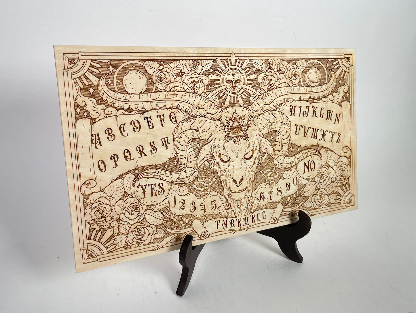 Celestial wooden Ouija board engraved with roses sun and skull symbols with wooden planchette for spiritualism and Wiccan ritual
