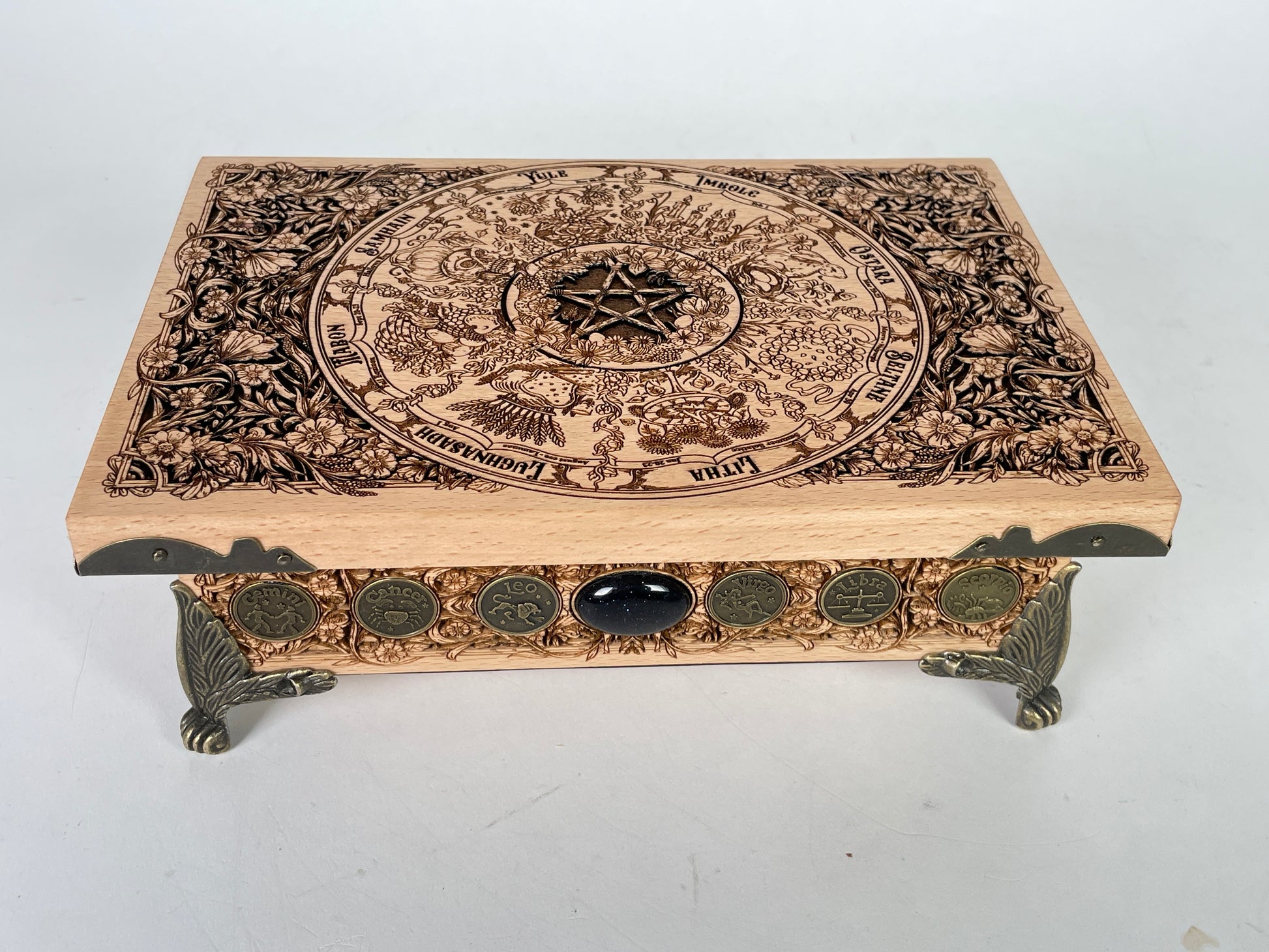 Decorative Wheel of the Year wooden box with intricate carvings and a pentagram design on a white background