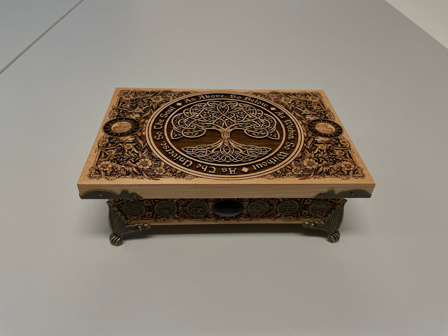 Wooden box with intricate tree of life  carvings on a white background