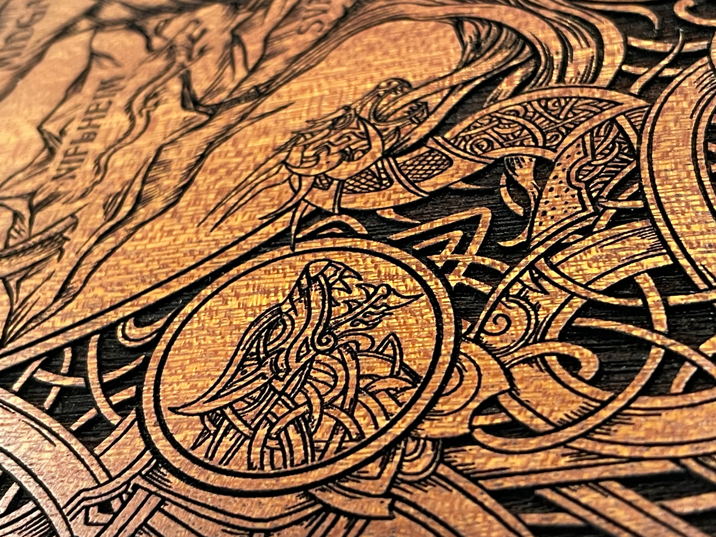 Close up of engraved Yggdrasil Tree of Life on mahogany wood with gold accents
