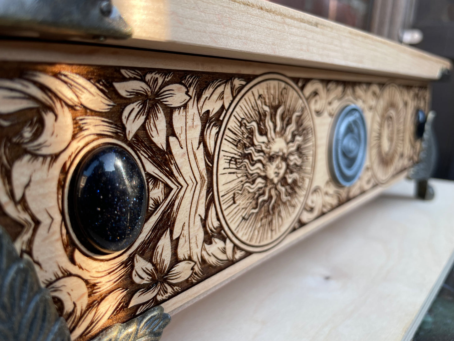 Close up of alchemical and zodiac symbol engraving on wooden tarot box
