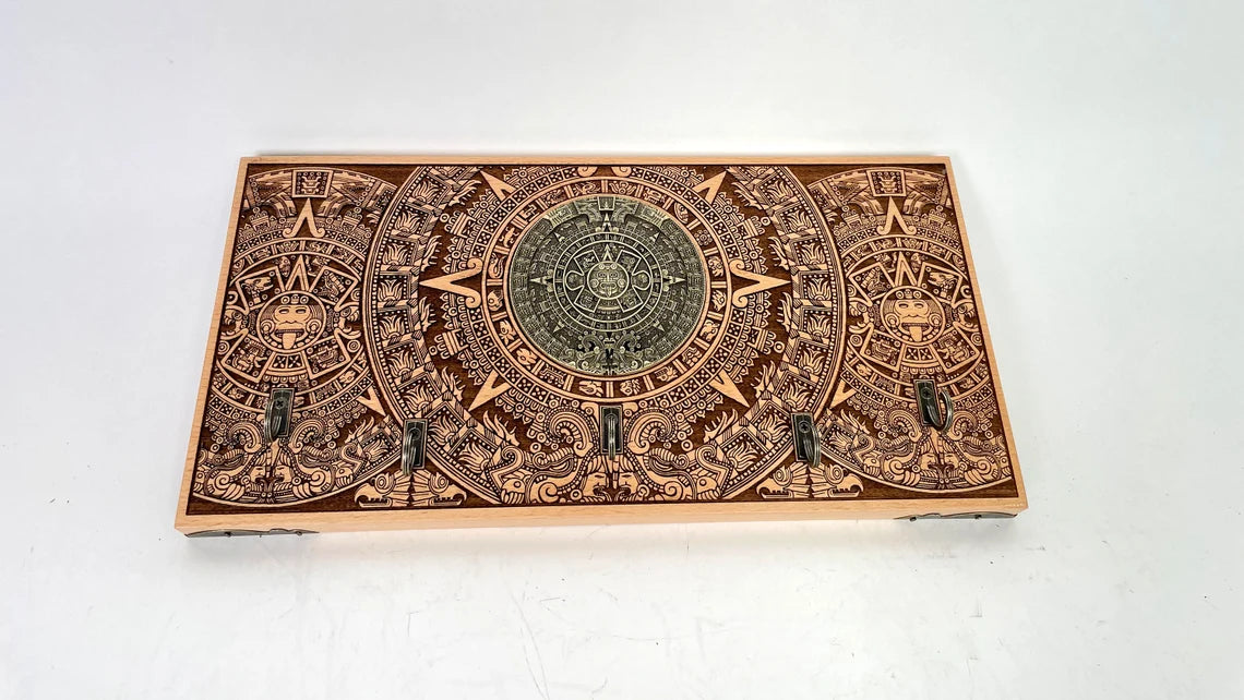 Mayan calendar key holder mounted on wall holding keys and small items
