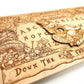 Side view of engraved wooden Wonderland Ouija board showing natural wood grain
