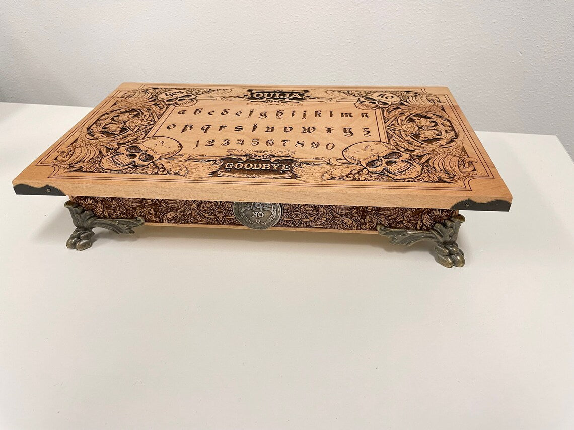 Handmade 2-in-1 Ouija board box set engraved in wood with gothic skull and demon design, includes planchette and storage compartment